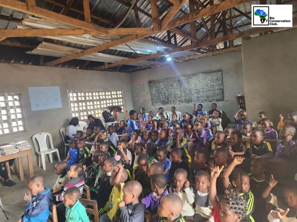 Students seated in a classroom, with several hands raised during a learning session.